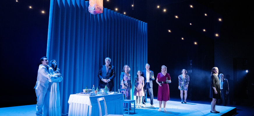 Bilden visar en scen ur föreställningen. Ljuset i taket föreställer stjärnor och hela scenen har ett kallt blåvitt ljus, många av skådespelarna scens i denna scen.