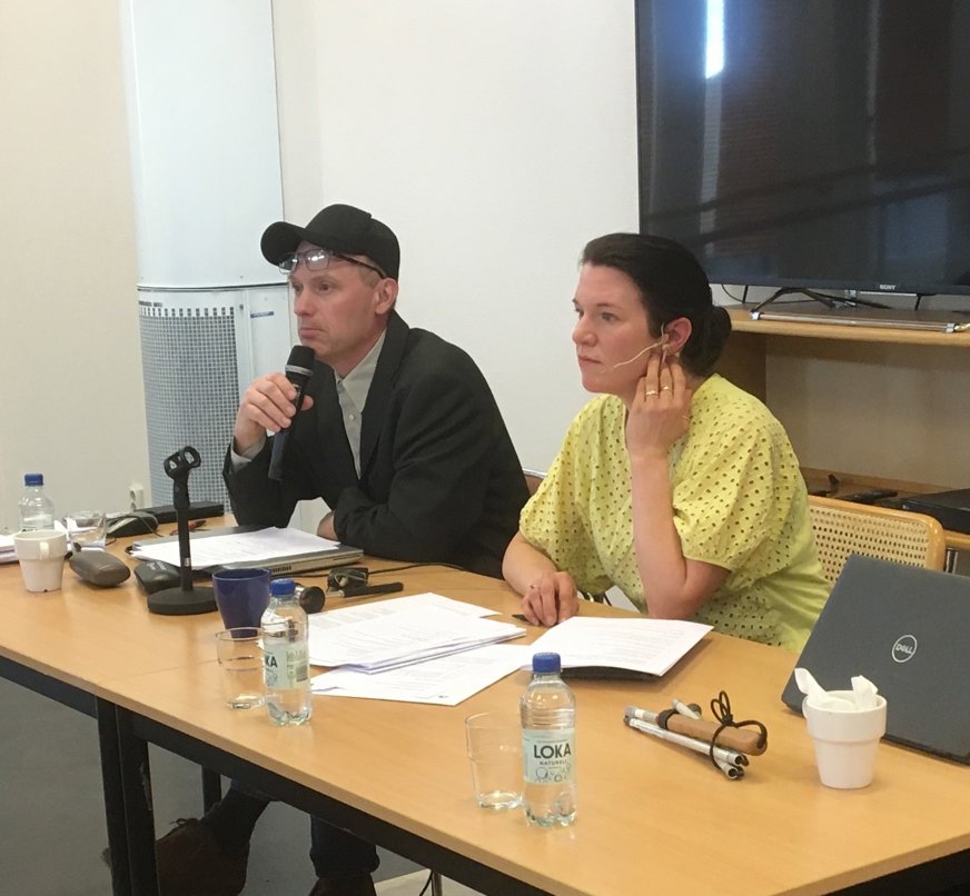 SRF Uppsala läns ordförande Tomas Wallén sitter och pratar i en mikrofon bredvid årsmötets ordförande, riksdagsledamot Lina Nordquist (L).