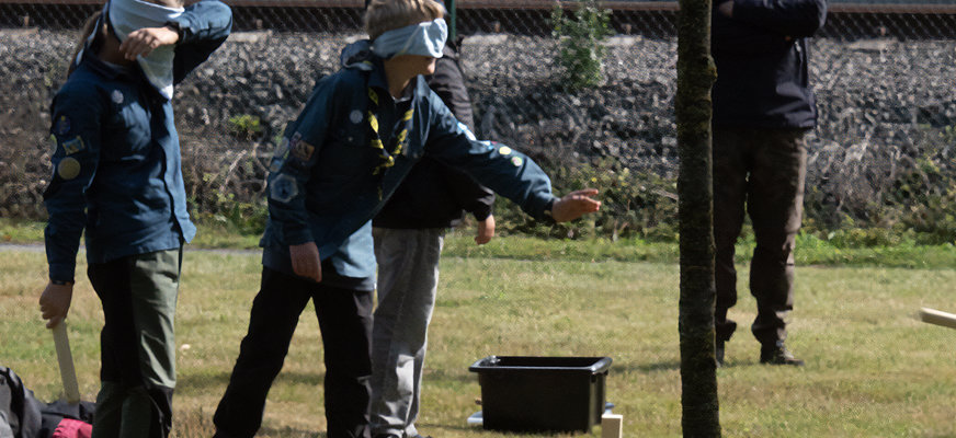 Bild på scout-ungdomar med ögonbindel som spelar kubb