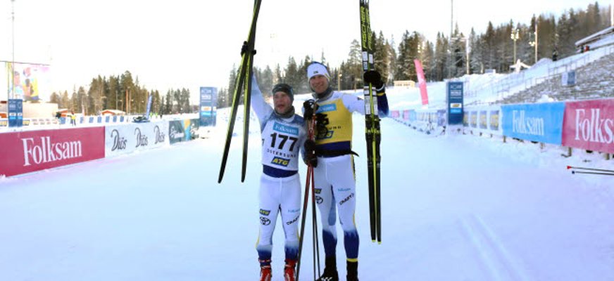 Två personer håller upp skidor