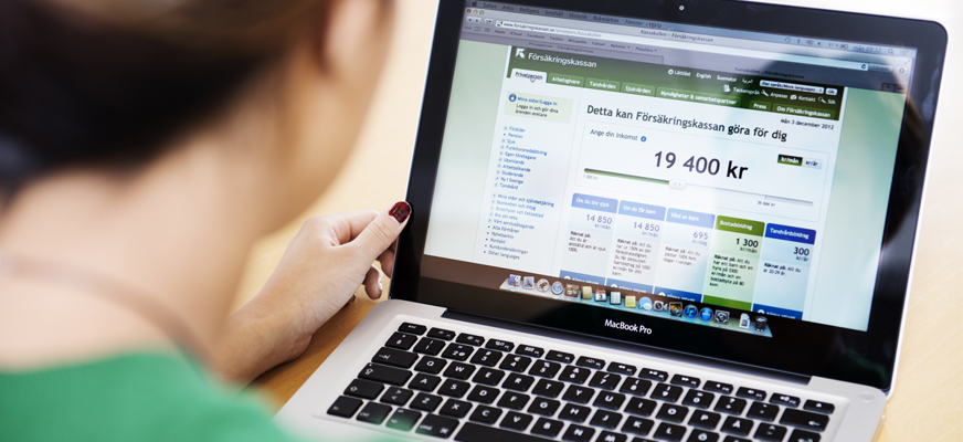 Kvinna fotad bakifrån. Sitter vid laptop, surfar på Försäkringskassans webb och tjänsten "Kassakollen".
