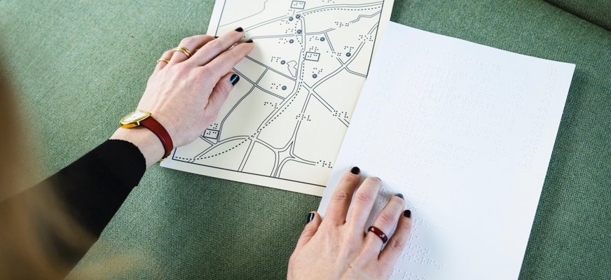 Två händer över en taktil karta.