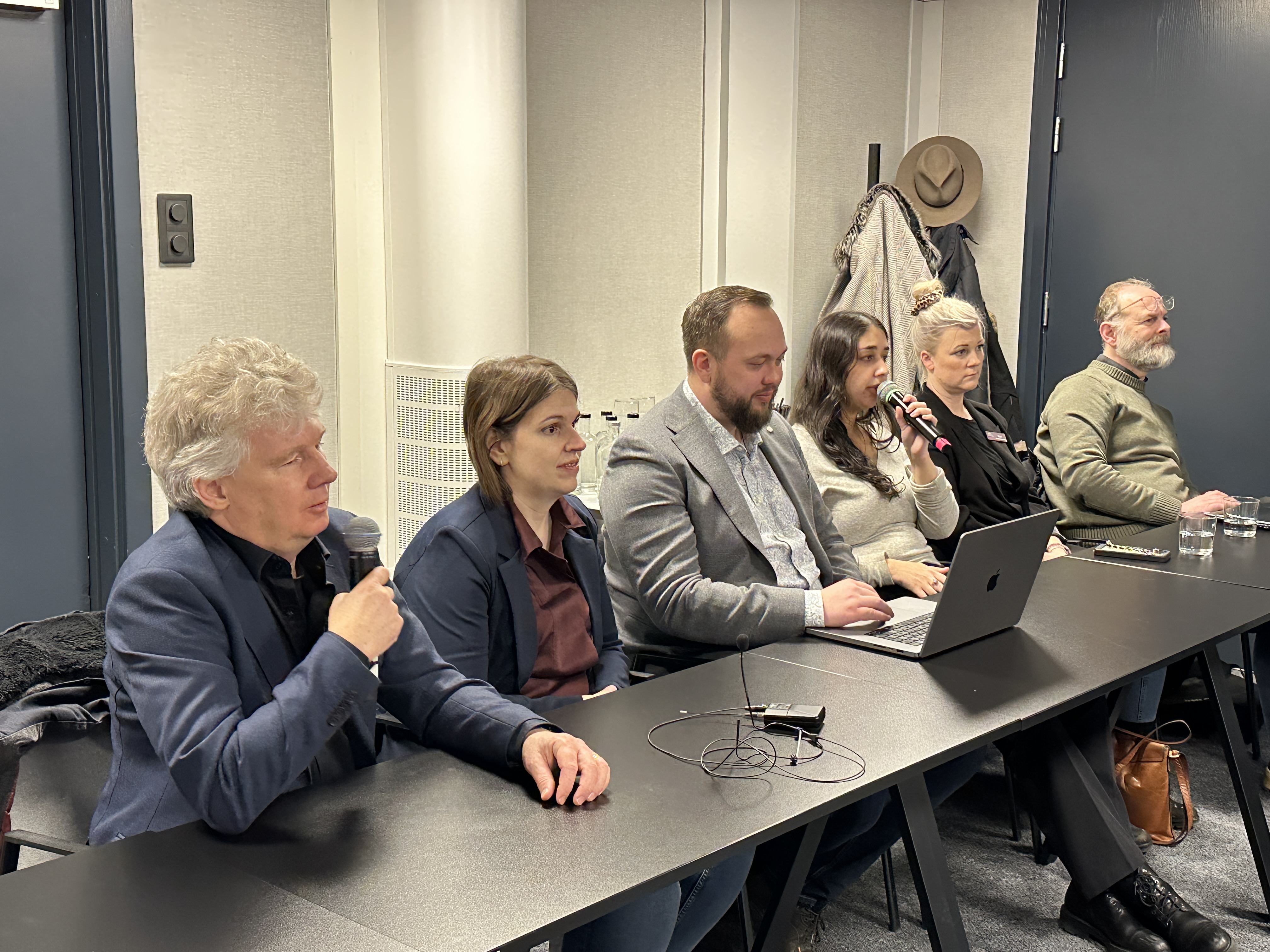 SRF:s Niklas Mattsson, Belmina Koca och Anders Ziethén tillsammans med representanter från US och FSDB. De sitter uppradade vid ett bord. Niklas Mattsson och Kadria Alizadeh från US pratar i mikrofoner.