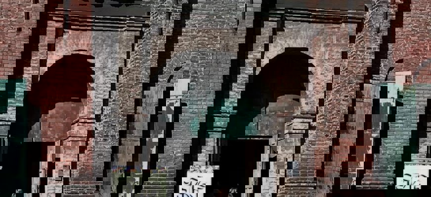 Bilden visar ett rum fullt med människor som sitter vid bord. Personerna är vända mot en gemensam punkt utanför bildens högra kant. Det är dagsljus utanför fönstren och lokalen har stora fönster, vita väggar och tak med inbyggd belysning. Stämningen verkar vara fokuserad och social.