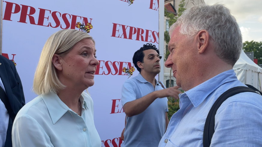Niklas Mattsson intervjuar Magdalena Andersson (S) vid Expressens backdrop. Magdalena har vit pikétröja och blond page.