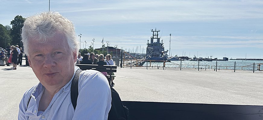 Bild på Niklas Mattsson, SRF:s ordförande, i Visbys hamn. Det är soligt och i bakgrunden syns en färja.