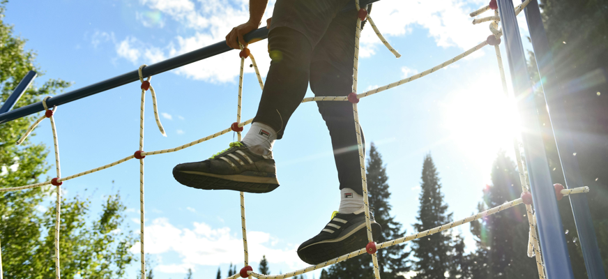 En person som klättrar över ett näthinder i en hinderbana.