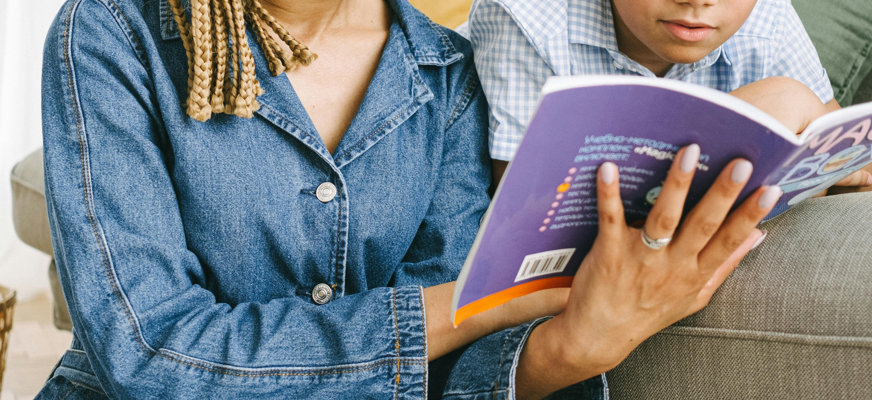 Mamma läser bok för sin son.