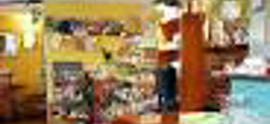 Inomhusbild på disken med alla kakor. Mysig miljö med gula väggar och affärsdisken är stor och av trä.