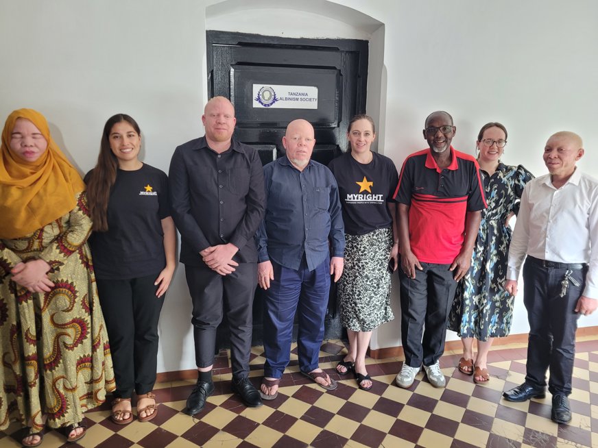 Två personer från MY Right och en från SRF står uppradade utanför Tanzania Albinism Society (TAS) tillsammans med fem personer från organisationen. Fyra av dem har albinism.
