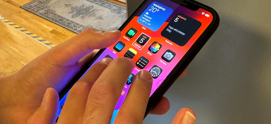 Händer som håller i en mobiltelefon.