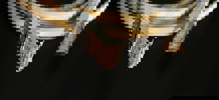 En grå nätverkskabel mot en svart bakgrund.