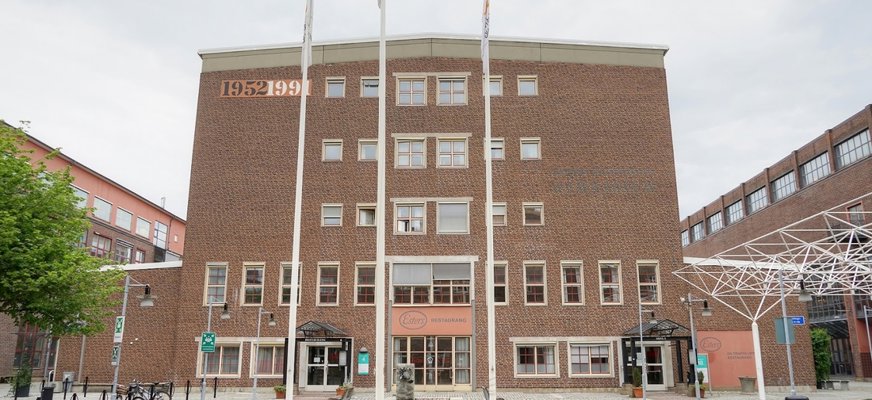 Bilden visar utsidan på Esters Restaurang, en stor 5 våningar hög tegelbyggnad