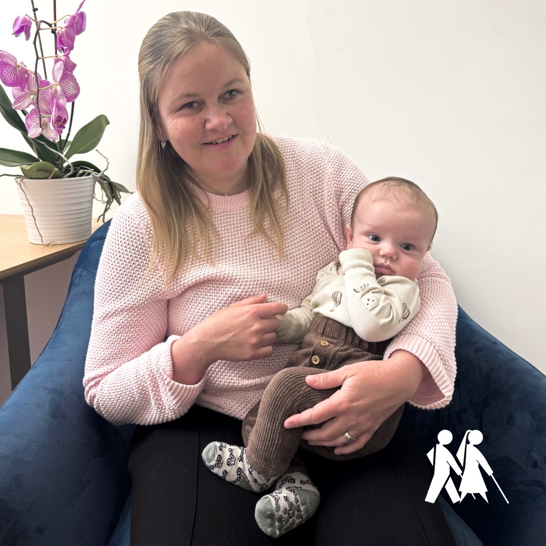 Josefin har rosa tröja och blont hår. Hon håller i en liten bebis med pigg blick och lite brunt hår på huvudet.