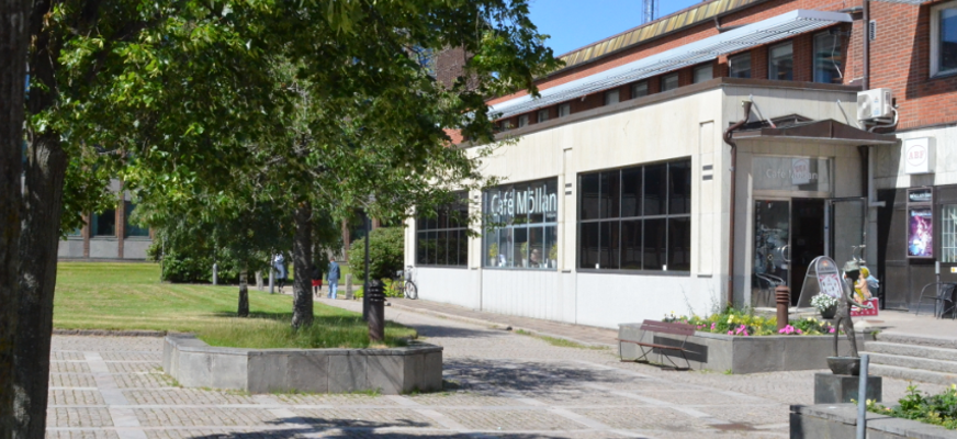Bilden visar utsidan av Café Möllan. Man ser även lite träd och stenläggning