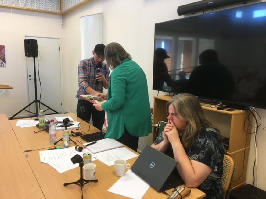 SRF Uppsala läns årsmöte 2023. Tomas Wallén överlämnar en chokladask till mötesordförande Anna-Karin Vaz Contreiras.