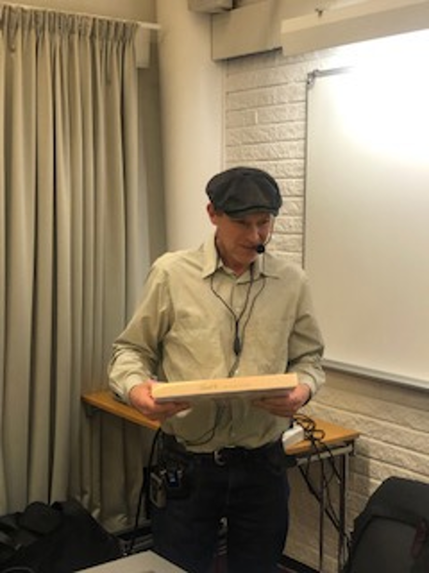 SRF Uppsala läns ordförande Tomas Wallén håller i en chokladask som han är på väg att lämna över till mötesordförande Vivianne Macdisi.
