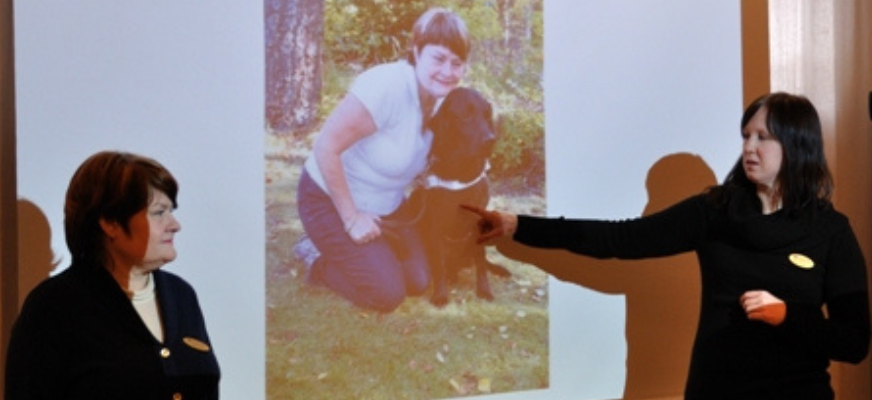 Två kvinnor informerar om ledarhundar med hjälp av powerpoint
