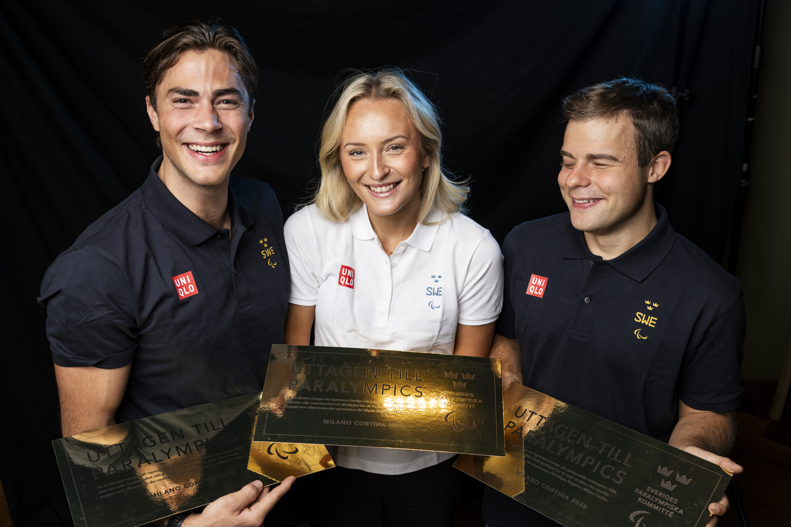 Aaron Lindström, Ebba Årsjö och Zebastian Modin har blivit uttagna till den Svenska truppen i Paralympics Milano Cortina 2026. De poserar framför kameran och ler stort.