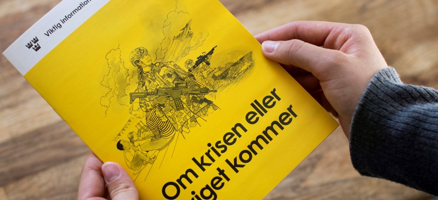 Två händer håller i broschyren ”Om krisen eller kriget kommer”. Foto: MSB, Myndigheten för samhällsskydd och beredskap.